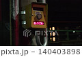 Close-up of a hand pressing a pedestrian signal button on a street at night. 140403898