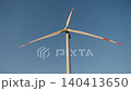 Close up view of wind turbine with blades turning against clear blue sky. Clean renewable energy and sustainable technology concept. 140413650