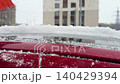 a girl cleans her personal car from snow with a black-and-orange car brush in the courtyard of an apartment building. Video FullHD 140429394
