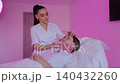 Esthetician performing kinesiology taping facial treatment 140432260