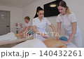 Professional massage therapist teaching student back massage techniques 140432261