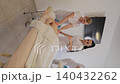 Massage therapists training with a client at a spa 140432262