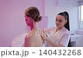 Aesthetician applying kinesiology tape on woman's neck and shoulder 140432268