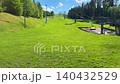 Slope of summer ski resort with chairlift on green mountain, sunny landscape for outdoor recreation in alpine park. 140432529