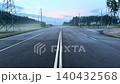 A flooded road after rain with power lines and a foggy pine forest at dawn, a landscape of rural transport and energy infrastructure. 140432568