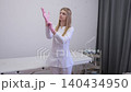 Professional female cosmetologist putting on pink latex gloves 140434950