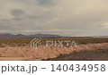 Barren desert landscape with distant mountains 140434958