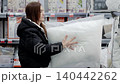 Young woman is choosing a pillow in the bedding department of a home goods store. She is holding and inspecting a pillow 140442262