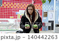 Young woman is choosing avocados in the fresh produce section of a supermarket. She is comparing two avocados in her hands 140442263