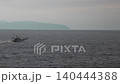 [4K] 一艘漁船航行在廣闊的海洋上，背景是一座島嶼的輪廓，屬於通用背景資料。 140444388