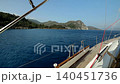 View from the wooden deck of a yacht with metal handrails onto the mountainous sea coast on a sunny day 140451736