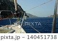 A view through the yacht's protective railings onto a sea bay surrounded by rocky shores 140451738