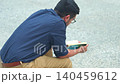 A man reads a book while sitting in a public plaza in Chicago. The scene shows concentration and quiet moments in a busy urban environment. 140459612