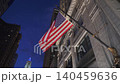 American flag hanging on a historic building facade in Chicago downtown with illuminated architecture at night. Iconic city landmark scene with classic details and urban skyline in the background. 140459636