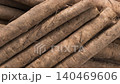 A close-up of fresh burdock roots arranged in bundles on a wooden table. 140469606