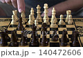 the hand moves the chess pieces on the board 140472606