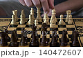 the hand moves the chess pieces on the board 140472607