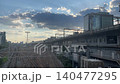The railway tracks leading to the Shinkansen station and the surrounding cityscape (a business district at dusk with clouds). 140477295