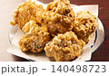 Fried chicken served on a white plate lined with parchment paper. 140498723