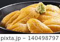 A luxurious seafood dish featuring fresh sea urchin from Hokkaido piled high in a glass bowl. 140498797