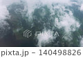 Aerial View of Clouds Moving Over Earth from Airplane Window while Flight 140498826