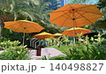 Yellow Parasols in Tropical Hotel Garden Terrace with City Background 140498827