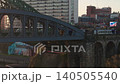 Static aerial telephoto shot of a Northern Rail passenger train crossing the Monkwearmouth Railway Bridge into Sunderland city center at dawn. 140505540