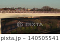 Aerial tracking shot flying sideways along the Keel Crossing pedestrian bridge in Sunderland at sunrise, showing the modern architecture and urban landscape. 140505541