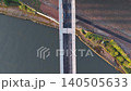 Top-down aerial drone tracking shot of a pedestrian walking across the Keel Crossing bridge in Sunderland at dawn, showcasing the modern architectural design and river landscape. 140505633