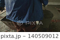 Professional builder in workwear taking liquid concrete with a bucket from a container and pouring it on the floor, leveling the surface of a new building during renovation work 140509012