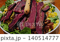This is a salad with beef in the bowl 140514777