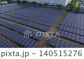 [Aerial view] Panoramic view of a vast mega solar power plant adjacent to a factory and baseball field (Land use, renewable energy, SDGs) 140515276