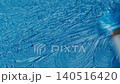 An artist mixing the blue oil paint on a transparent glass palette with round brush. Relaxing close 140516420