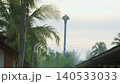 Water tower stands tall in Thailand surrounded by palm trees. It provides essential water supply for farming and plumbing activities in the area. Morning fog covers the landscape. High quality 4k 140533033