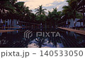 Watch as dawn breaks at a resort hotel in Thailand. The timelapse shows the pool and palm trees transforming with light. Early morning colors reflect off the water's surface. High quality 4k footage 140533050