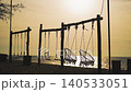 Timelapse Families and friends swing on beach swings as the sun sets on the horizon. The calm ocean reflects the golden light while people enjoy the beautiful outdoors time lapse. High quality 4k 140533051