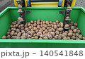 Automatic potato planter machine working in the field close up. Agricultural machinery planting seed potatoes into the soil. Modern farming process and food production technology in spring. 140541848