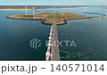 Aerial view of the Oosterscheldekering storm surge barrier with highway road and offshore wind turbines at Delta Works in Zeeland, Netherlands. 140571014