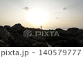 Woman watching the sunset from a rocky coast, Thailand 140579777