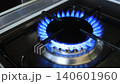 Blue gas flame burning on household kitchen stove in dark interior, close up view of natural gas consumption, domestic energy use, rising gas prices, utility bills, energy crisis, inflation, household 140601960