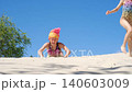 Funny laughing Girls in swimsuits playing with sand on the beach by the sea. Vacation at the resort 140603009