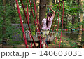 A child climbs through shoelaces over obstacles on a cable car in the park 140603031