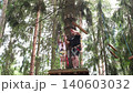 The father helps the child to attach the carbine to the trigger device for climbing and rope descent. An active recreation park 140603032