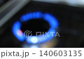 The blue flame of a gas burner on a kitchen stove is out of focus and blurred in slow motion. Close-up of a household gas stove in a dark room, energy consumption during cooking, gas consumption 140603135