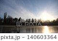 Girl in figure skates is skating on ice surface at sunset time. Young woman training alone at frozen river or lake. Lady improves skills and have active leisure at winter cold weather. Slow motion 140603364