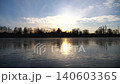 Young man skating on frozen river during sunset time. Guy shod in figure skates sliding on icy lake during training. Shining sun is reflecting on surface of ice. Active leisure at winter. Slow motion 140603365