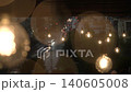 shot cafe set roof building, raindrops falling garland yellow light bulbs, moved wind, car headlights shining background below twilight summer day. blurred raindrops, bokeh warm incandescent lights 140605008