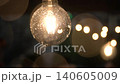 Raindrops falling on a garland bulb, the wind moves it, close-up shot, aesthetic video, decor. blurred raindrops, bokeh of warm incandescent lights 140605009