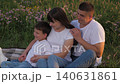 man woman relax hugging child outdoors, little child with father mother parents, family communication outdoors, group people picnic in park, happy people, husband wife with son on green meadow flowers 140631861