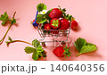 strawberries in small grocery cart on light pink background 140640356